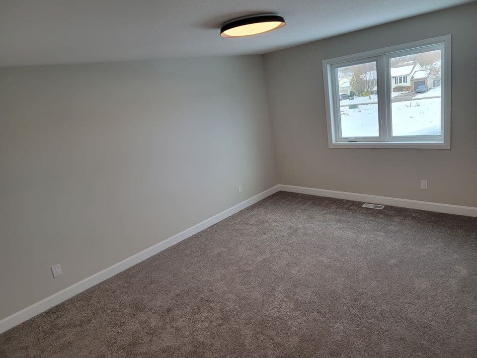 Carpeted bedroom with a large double window