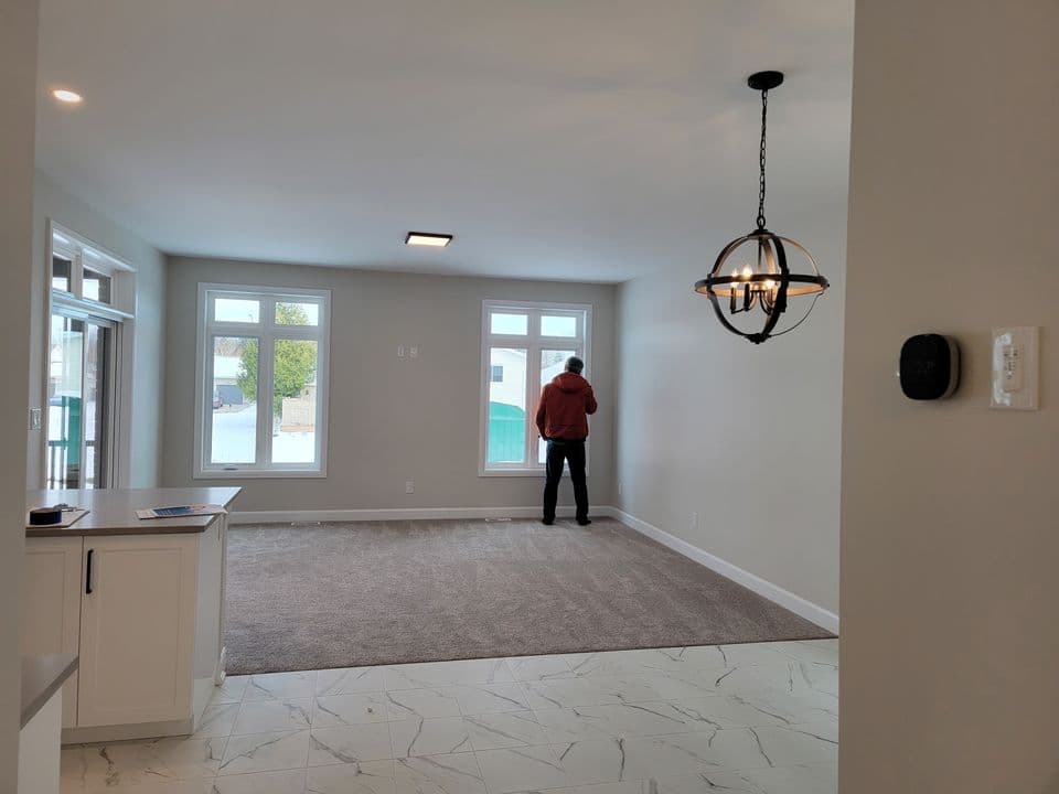 Great room with two tall windows and a wrought iron chandelier