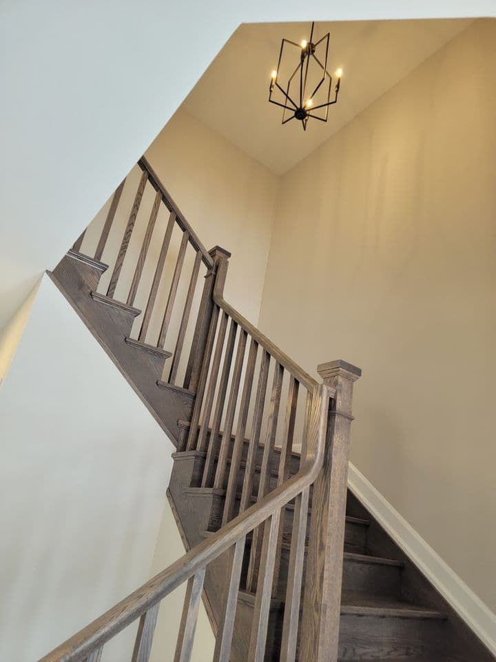 Oak staircase with metal spindles rising to the second floor landing