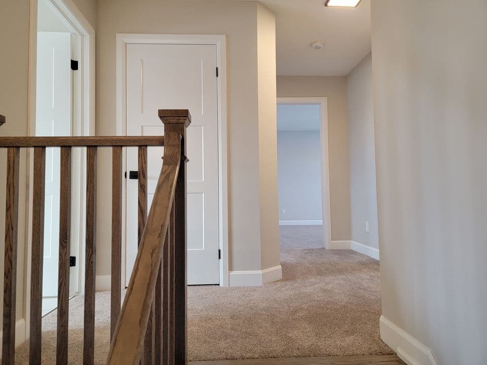 Carpeted second floor landing with bedroom doorways